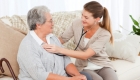 caregiver checking on elder woman